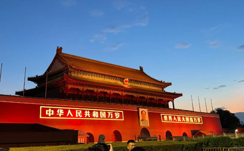 Illuminated Tiananmen Gate Tower at night with golden roof lighting